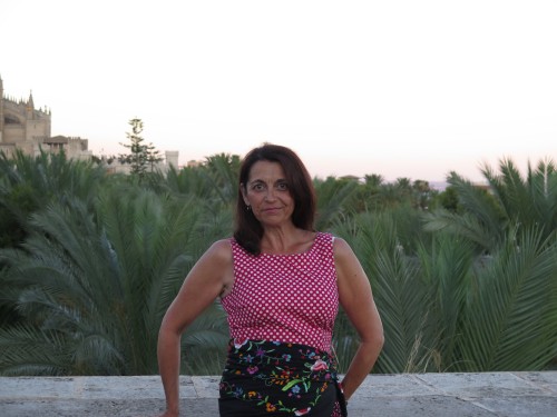 Suzanne Steele standing in front of palm leaves