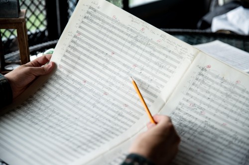 person reading through an orchestral score